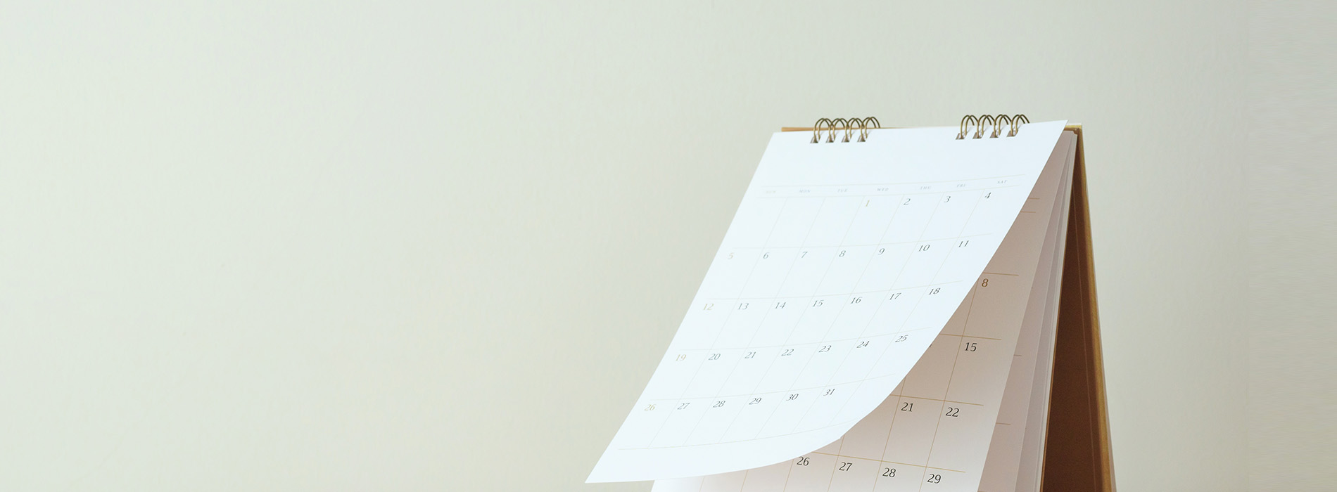 The image shows a desk calendar with a visible spiral binding, displayed against a plain background.